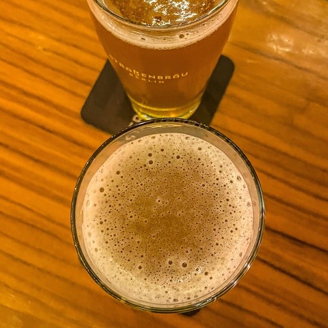Zwei Gläser mit frisch gezapftem Pale Ale auf dem Tisch in der Bar, von oben fotografiert 