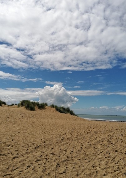 Strandbild mit Düne und Wolken