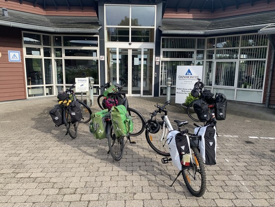 Fünf Fahrräder mit Gepäck vor dem Eingang des Hostels.