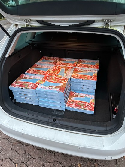 Ich im Kofferraum eines Golf Kombi mit 41 Pizzakartons in 9 Stapeln 