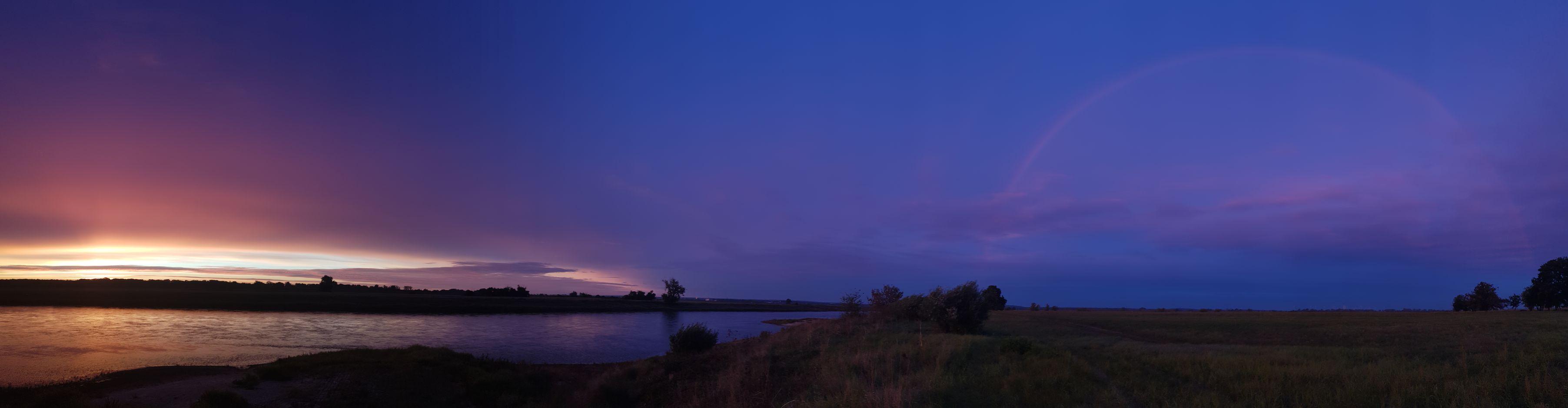 Panorama, Himmel noch weitgehend nachtdunkel, links kündigt sich der Sonnenaufgang mit Helligkeit und Farben an, rechts steht ein Regenbogen vor nachtblauem Himmel. Die Elbe ist auch da, spiegelt ungläubig die Farben, so gut sie kann. Panorama, Himmel noch weitgehend nachtdunkel, links kündigt sich der Sonnenaufgang mit Helligkeit und Farben an, rechts steht ein Regenbogen vor nachtblauem Himmel. Die Elbe ist auch da, spiegelt ungläubig die Farben, so gut sie kann.