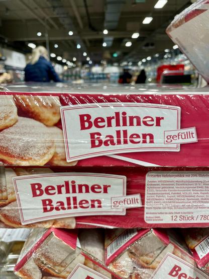 Frittiertes Süßgebäck mit Puderzucker, auf der Packung steht „Berliner Ballen“. . 